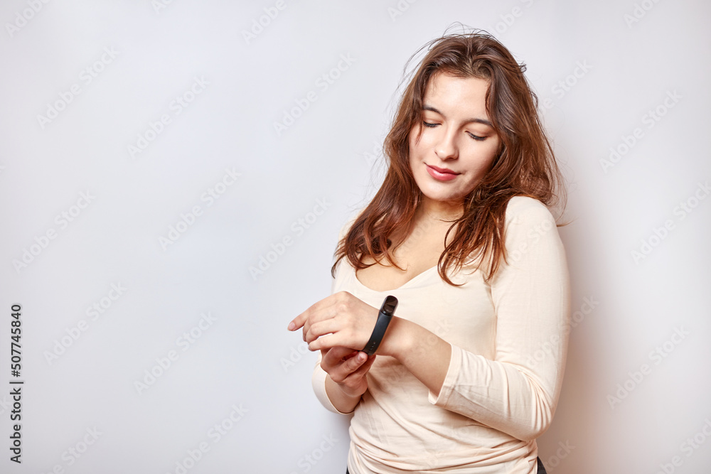 Naklejka premium Girl with a fitness bracelet on her arm. Modern gadgets and digital technologies in human life.