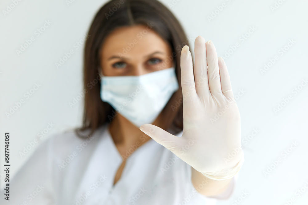 Help stop spreading globally coronavirus pandemic infectious disease outbreak. On background woman in mask focus on stretched hand as symbol of keep distance avoid communication