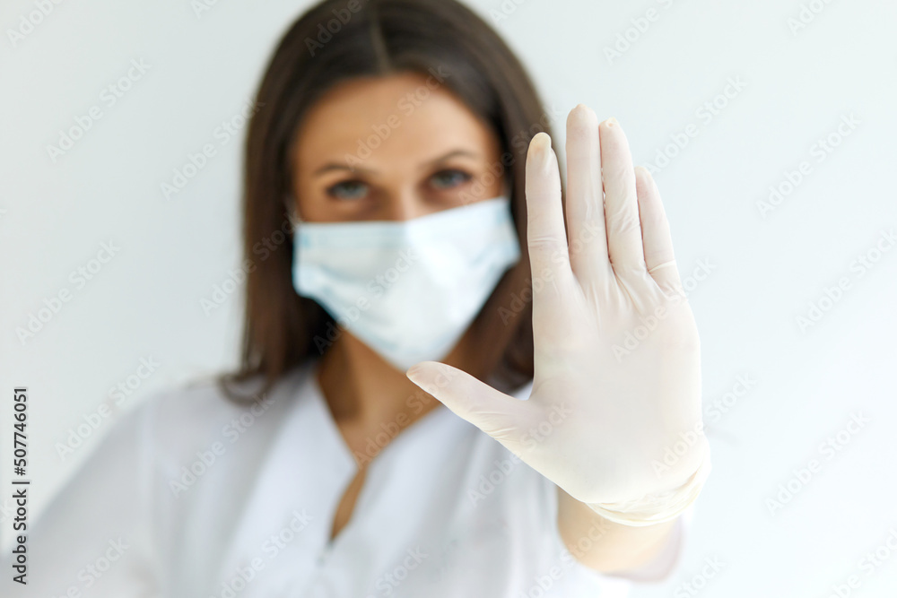 Help stop spreading globally coronavirus pandemic infectious disease outbreak. On background woman in mask focus on stretched hand as symbol of keep distance avoid communication Help stop spreading globally coronavirus pandemic infectious disease outbreak. On background woman in mask focus on stretched hand as symbol of keep distance avoid communication