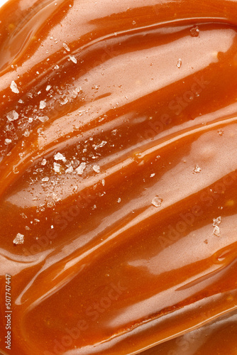 Liquid salted caramel syrup. Background of salted caramel paste. Texture Close up, top view.