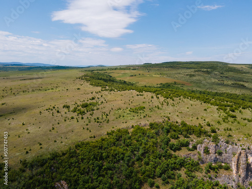 Landscape of green mountain hill and blue sky with white clouds © Miro Nenchev