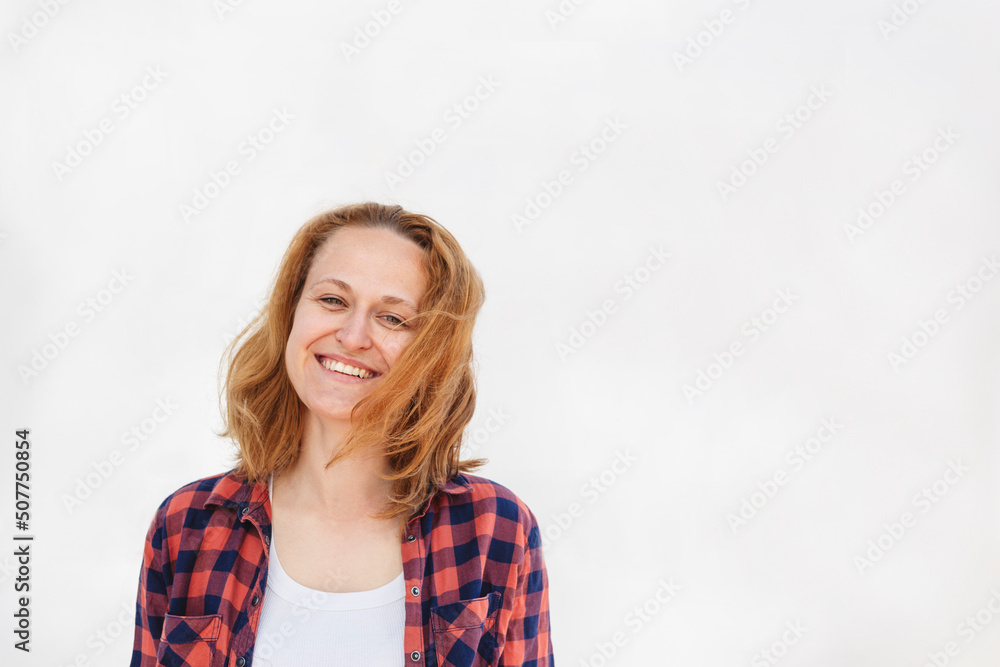 Happy woman wearing plaid shirt standing against white background Happy woman wearing plaid shirt standing against white background