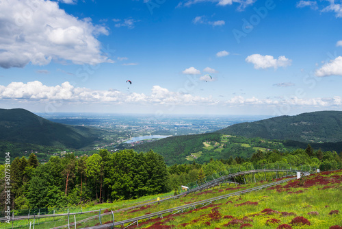 Fototapeta Naklejka Na Ścianę i Meble -  Panoramic view from the top of the heat towards the north. The summer toboggan run . Lake Czanieckie and the Międzybrodzkie in the background. View of the Silesian Beskids and the Little Beskids.