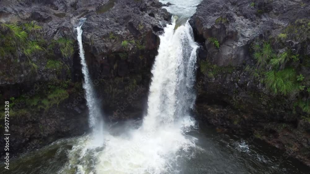 4K cinematic crane drone shot of a waterfall raging over a cliff in a rainforest near Hilo on the Big Island of Hawaii. This awe-inspiring scene was filmed using a DJI Mini 2 drone. 4K cinematic crane drone shot of a waterfall raging over a cliff in a rainforest near Hilo on the Big Island of Hawaii. This awe-inspiring scene was filmed using a DJI Mini 2 drone.