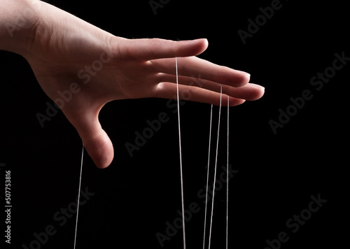 Woman hand with strings on fingers. Victim of domestic violence, slavery. Negative abusive relationship, manipulation, control, power concept. High quality photo