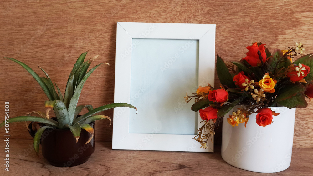 flowers in a vase with photo frame and plant