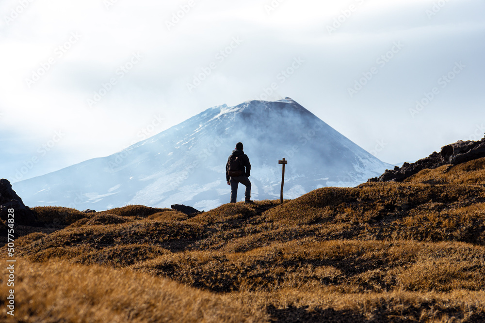 Man looking at the Volcano in a cloudy day in Sicily.