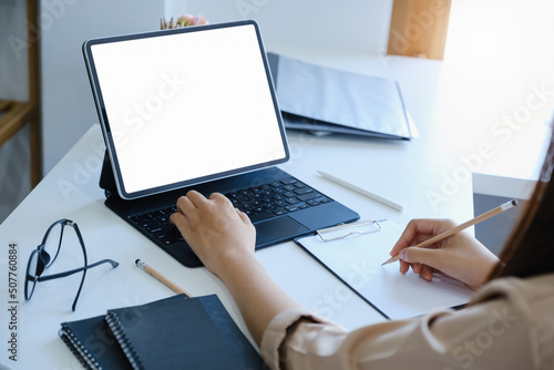A woman using tablet with a blank white screen. The blank space on the white screen can be used to write a message or place an image