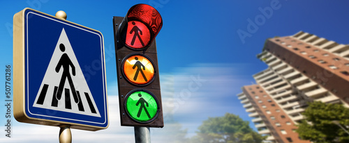 Close-up of a crosswalk sign and a pedestrian traffic light in the city with a clear blue sky and copy space. Italy, Europe.