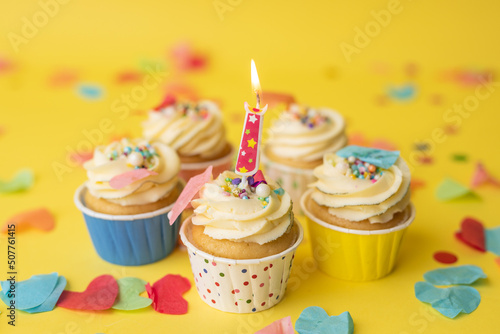 Birthday cupcakes in colorful colors on yellow background