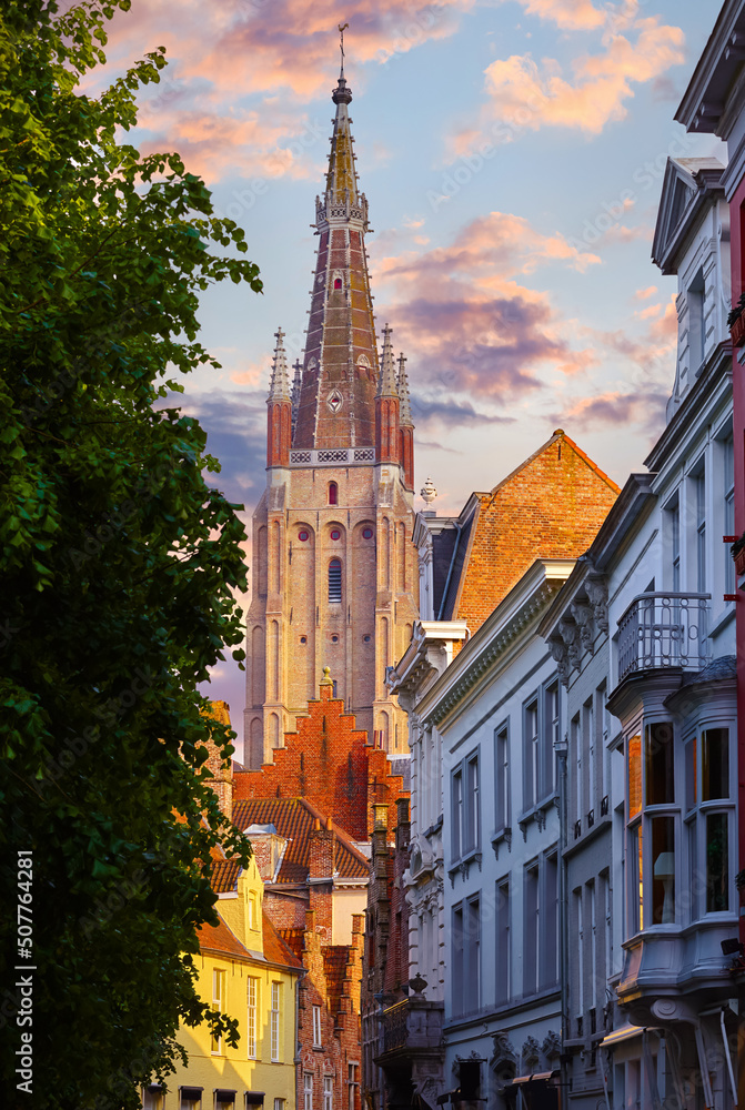 Obraz premium Bruges Belgium vintage stone houses and bridge over canal ancient medieval street picturesque landscape in summery sunny day with blue sky white clouds.