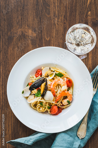 Spaghetti pasta with seafood sauce with shrimps, mussels, clams on wooden table. Italian typical recipe spaghetti allo scoglio, seafood spaghetti.