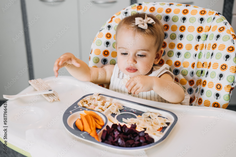 Babys first solid food. Solid food for little child 6 months old. Cute