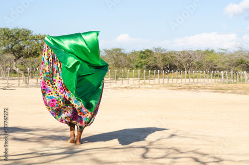 Woman dancing typical Wayuu dance. Indigenous culture of La Guajira, Colombia. Desert landscape. photo