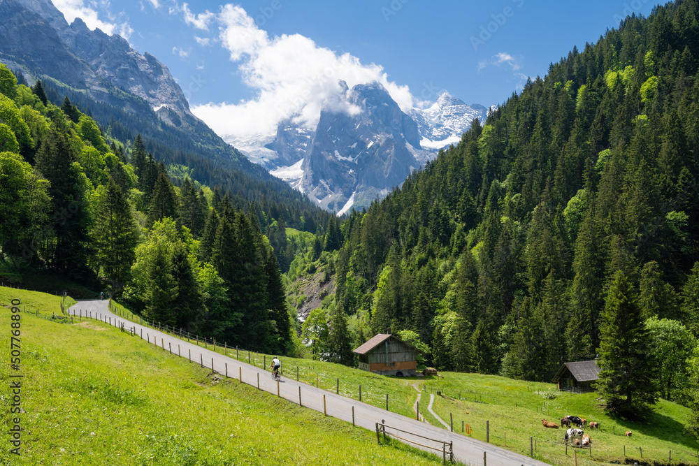 Cyclist in front of Wellhorn peak in Reichenbach valley in the Swiss Alps