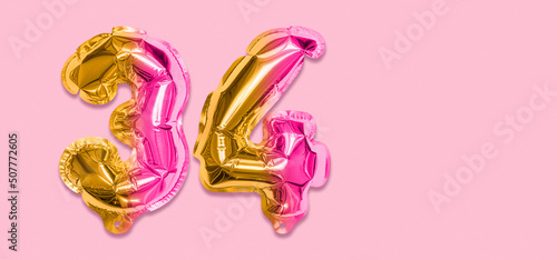 Rainbow foil balloon number, digit thirty four on a pink background. Birthday greeting card with inscription 34. Top view. Numerical digit. Celebration event, template. Banner photo