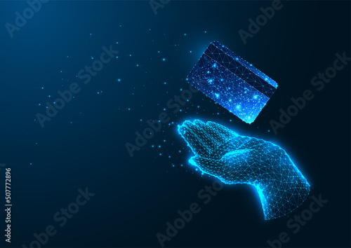 Futuristic online payment concept with glowing low polygonal hand holding credit card on dark blue