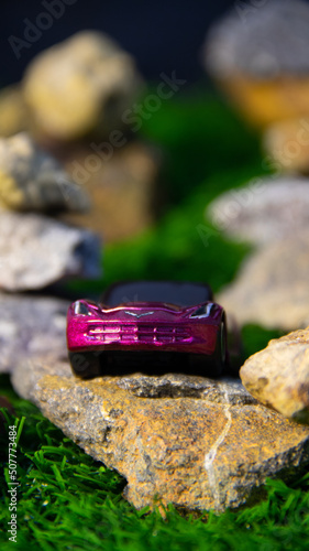 Toy car on rocks background with orange glow