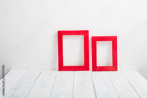 pair of empty red picture frames on white wooden table © tstock
