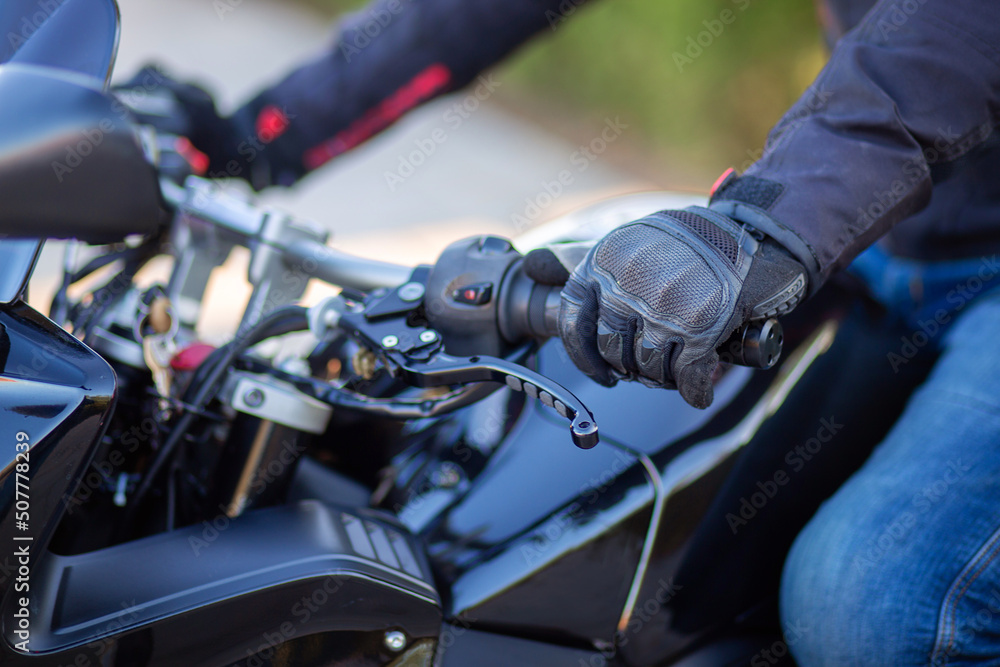 Obraz premium Motorcyclist holding the handlebars of a motorcycle