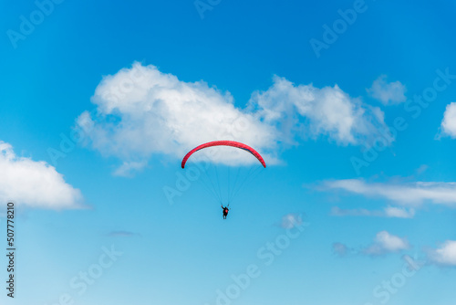Fototapeta Naklejka Na Ścianę i Meble -  Paraglider flight against a beautiful blue sky. Top view of the embers in the Beskid Mały. A popular place in Silesia. Bielsko Biała, Poland