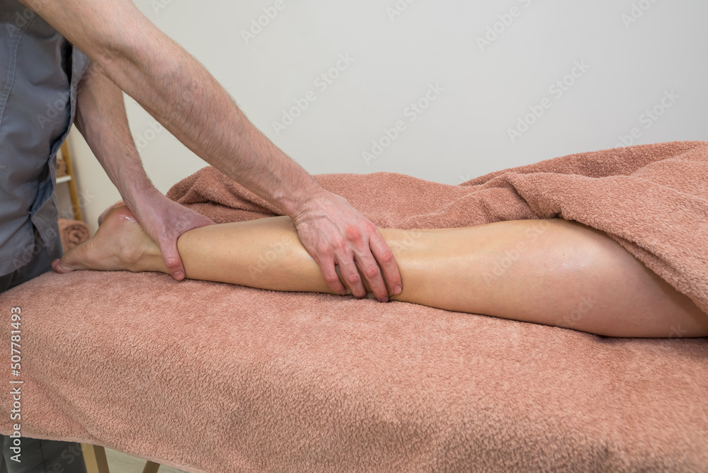 Calf massage in spa salon.