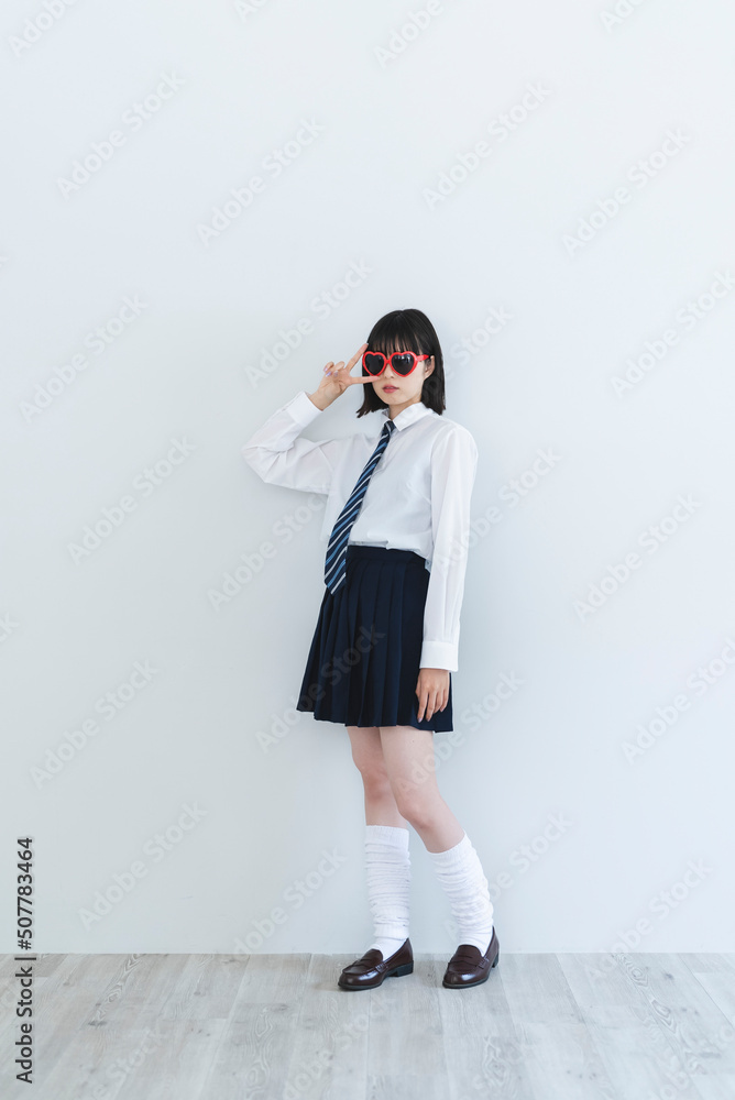 ハートのサングラスをかけてピースサインをする女子高生 ハートのサングラスをかけてピースサインをする女子高生