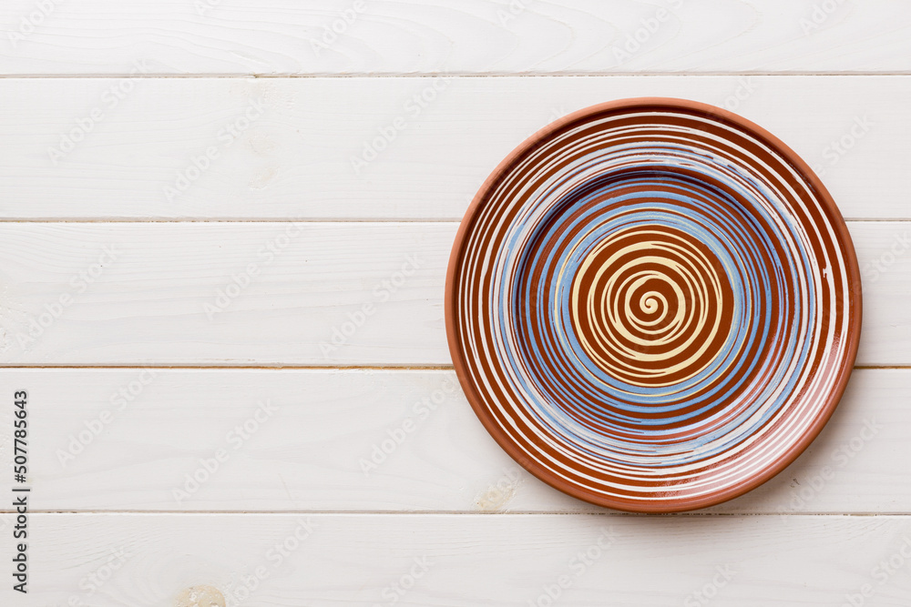 Top view of empty colorful plate on wooden background. Empty space for your design Top view of empty colorful plate on wooden background. Empty space for your design