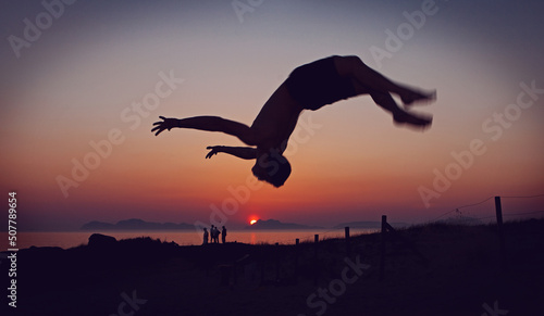 man doing backflip on a sunset background