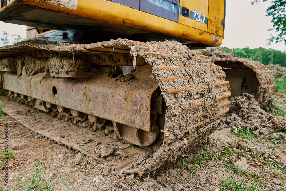 Yellow excavator on construction site, Heavy construction machine excavating soil, Crawler backhoe working at dirt soil