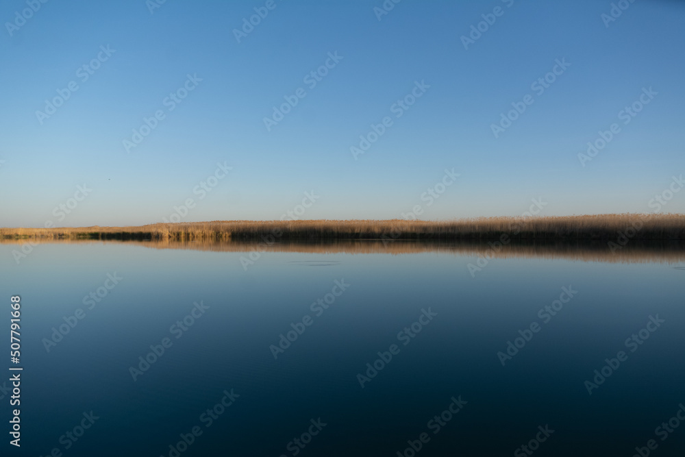 Landscape of sunset on Lake Balkhash with blue calm water in Kazakhstan. 