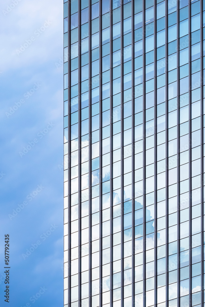 Sky reflection on surface of glass skyscraper against cloudy sky background in vertical frame Sky reflection on surface of glass skyscraper against cloudy sky background in vertical frame