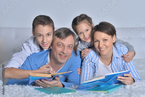 Family of four reading books together