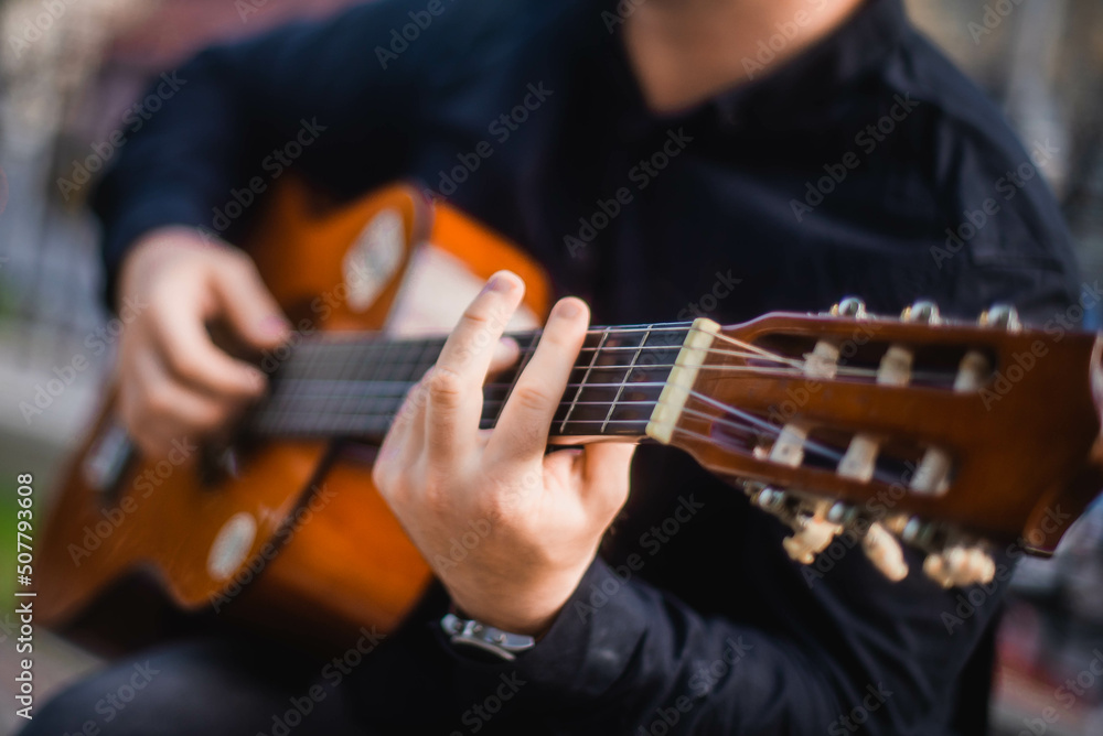 Obraz premium Street musician. A man plays the guitar on a city street.
