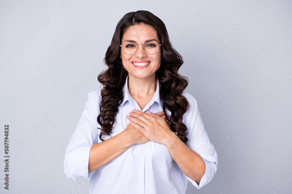 Photo of cute teacher brunette curly young lady hold arms wear spectacles blue outfit isolated on grey color background Photo of cute teacher brunette curly young lady hold arms wear spectacles blue outfit isolated on grey color background