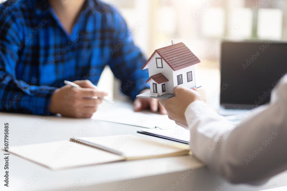 Real estate agents negotiate the terms of the home purchase contract and sign the contract legally. Home insurance concept. Real estate agents negotiate the terms of the home purchase contract and sign the contract legally. Home insurance concept.