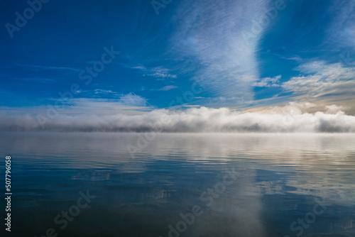Morning fog, foggy clouds on blue lake