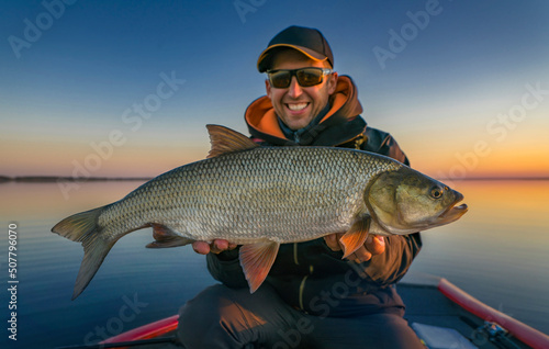 Asp fishing. Happy fisherman with big aspius fish