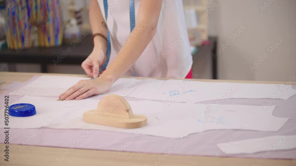 Women's hands measure pieces of cloth on a table Women's hands measure pieces of cloth on a table