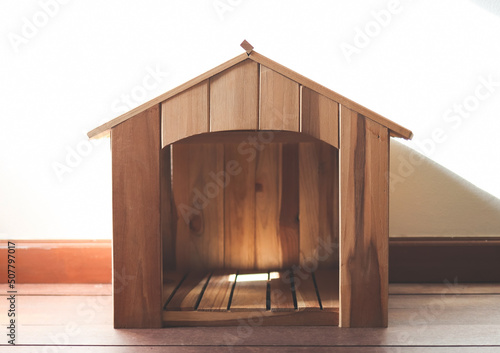 Foto wooden dog house in the room with wooden floor and white wall and morning sunlight