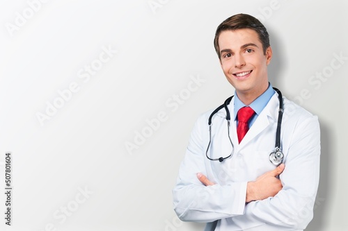 Happy young doctor in a white coat posing © BillionPhotos.com