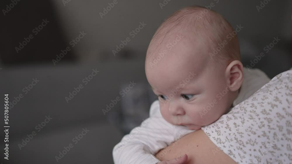 Young woman mom with baby girl on hands near window at home. The baby in the arms of his mother smiles. Young woman mom with baby girl on hands near window at home. The baby in the arms of his mother smiles.