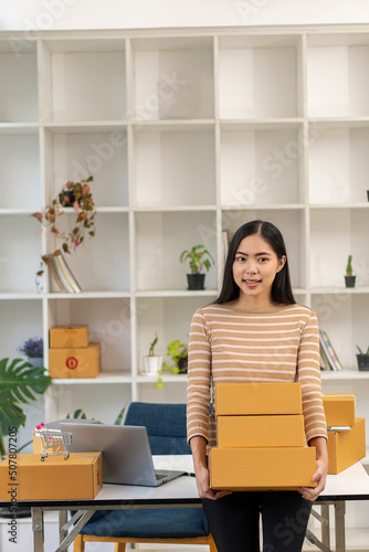 SME Startup Business Ideas, Young Entrepreneurs small business owners work at home with laptop and box Packaging and delivery situation Woman Small business owner packing goods in boxes.