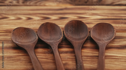 Wooden spoons from dark wood on a wooden table background