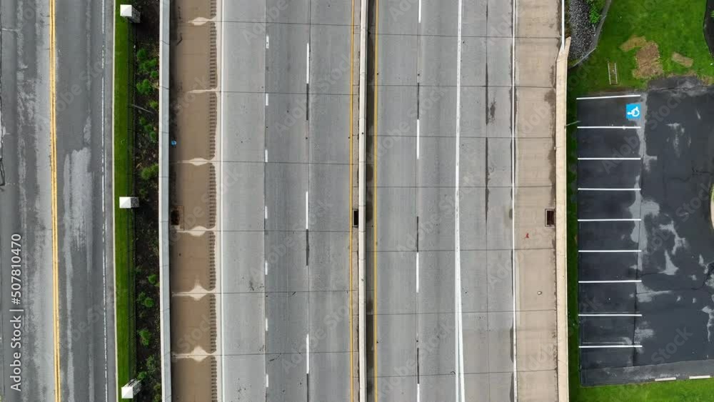 Aerial rising shot of highway with cars traveling across. Motor vehicles drive on motorway. Drone view of American infrastructure. Aerial rising shot of highway with cars traveling across. Motor vehicles drive on motorway. Drone view of American infrastructure.
