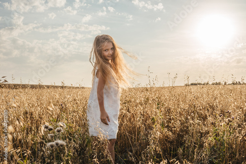 Little girl in field, sunset light.