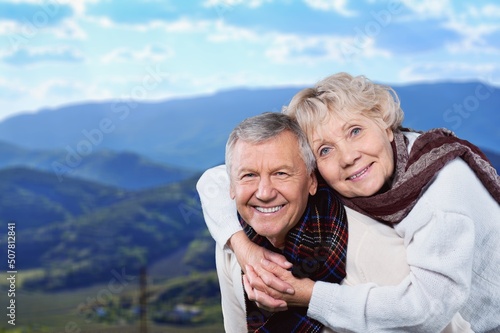 Portrait of an affectionate mature couple sitting on a pier out on a lake background