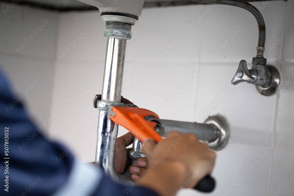 plumber at work in a bathroom, plumbing repair service, assemble and install concept. plumber at work in a bathroom, plumbing repair service, assemble and install concept.