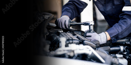 Professional mechanic working on the engine of the car in the garage. Car repair service. The concept of checking the readiness of the car before leaving.