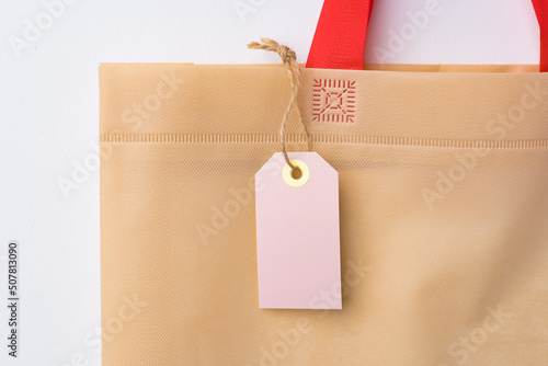 Blank paper tag with shopper paperbag on white background